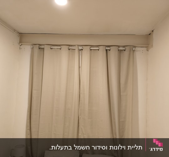 וילון תלוי על מוט בחדר עם קירות לבנים